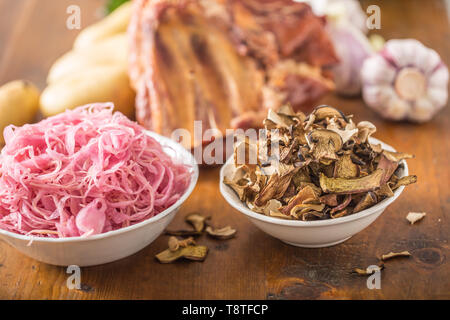 Sour cabbage and dried mushrooms in bowl on wooden table Stock Photo