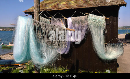 https://l450v.alamy.com/450v/t8tgjg/fishing-nets-dry-on-racks-in-bright-blue-green-shades-in-front-of-an-old-wooden-house-on-the-shores-of-the-vegetable-and-fishing-island-the-reichenau-t8tgjg.jpg