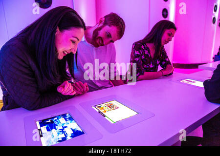 People playing VR games and ordering drinks on iPads embedded in the tables at Otherworld Virtual Reality Arcade and Bar, London, UK Stock Photo