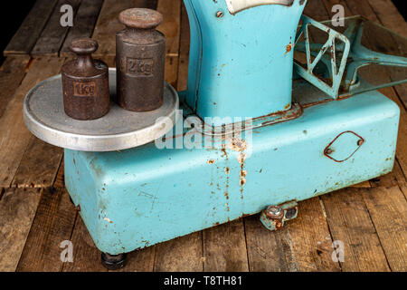 The old weight to weigh commodities from the communist era. Shop accessories on a stolen table. Dark background. Stock Photo