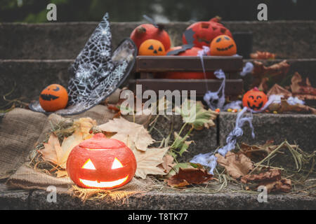 Halloween pumpkin with creative decorations on stairs outdoors Stock Photo