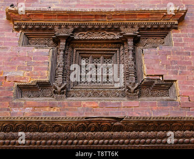 Window with carved wood screen in brick wall of Royal Palace, Sundari Chowk wing, Durbar Square, Patan, Kathmandu Valley, Nepal Stock Photo