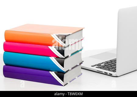 Computer and books on table on white background, isolated Stock Photo