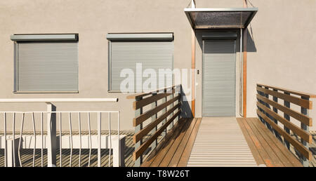 Light beige metal blinds on the doors and windows of the house Stock Photo