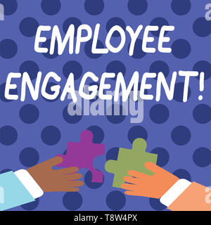 Handwriting text writing Employee Engagement. Conceptual photo relationship between an organization and its employees Two Hands Holding Colorful Jigsa Stock Photo