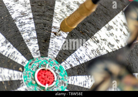 Darts Missing Bullseye on a Worn Out Dartboard. Proper Targeting, Losing Concept. Stock Photo