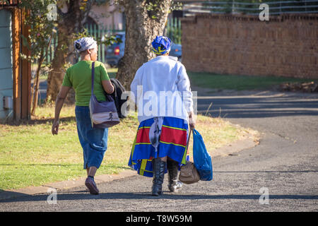 Johannesburg, South Africa - unidentified black women walk home in the afternoon from their jobs as domestic workers in the city