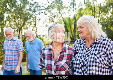 Two senior women talking while walking with friends in nature Stock Photo