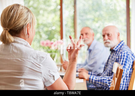 Teacher Explains Senior Citizens Work on Computer in Computer Course Stock Photo