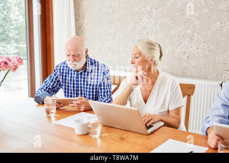 Couple of seniors using laptop and tablet computer is learning together in computer class Stock Photo