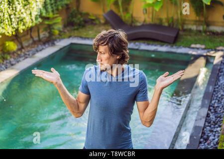 Man chooses chemicals for the pool. Swimming pool service and equipment with chemical cleaning products and tools Stock Photo