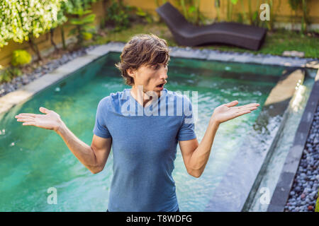 Man chooses chemicals for the pool. Swimming pool service and equipment with chemical cleaning products and tools Stock Photo