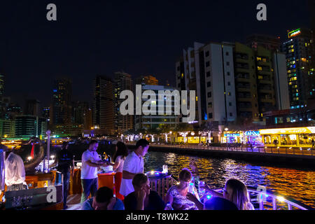 Dubai, UAE - November 29, 2018: Dinner for a group of tourists on the open deck of a cruise ship in Dubai Marina. Stock Photo