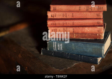 Soft focus image of a pile of old vintage hardcover books with the focus on the words Hans Christian Andersen and Fairy tales Stock Photo
