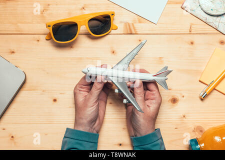 Summertime holiday vacation travel concept with model of airplane on the table, planning new adventure for this summer season, flat lay top view Stock Photo