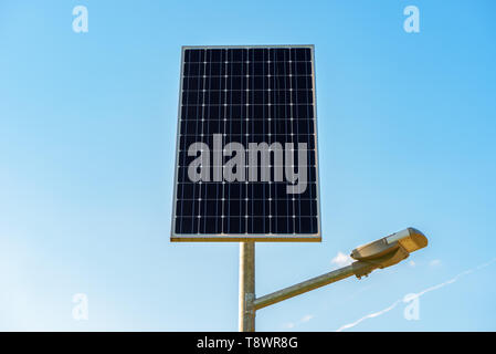 Single solar panel on the post against blue sky Stock Photo