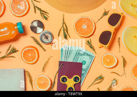 Money for travelling overseas. US dollars in passport with other summertime beach holiday accessories, top view flat lay Stock Photo