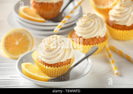Plate with delicious lemon cupcake on white table Stock Photo