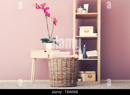 Wicker basket with folded clean towels on floor in bathroom Stock Photo