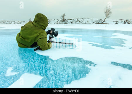 photographer takes pictures bubbles of methane gas frozen into clear ice lake baikal, russia Stock Photo