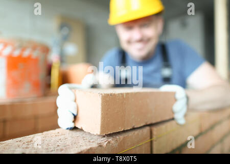 Male smiling builder puts make brickwork Stock Photo