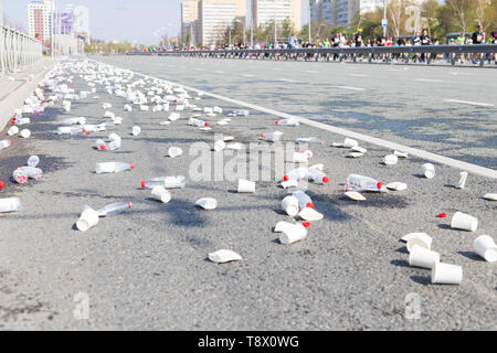 A bunch of plastic cups and empty bottles on the streets while a marathon running Stock Photo