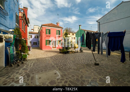 Colorfully painted houses on the island Burano, laundry is put up on washing lines Stock Photo