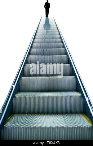 silhouette of a man in suit standing at the edge of an escalator Stock Photo
