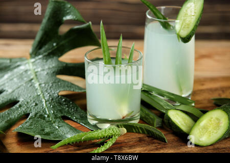 Glasses of fresh aloe vera juice with cucumber on wooden board Stock Photo