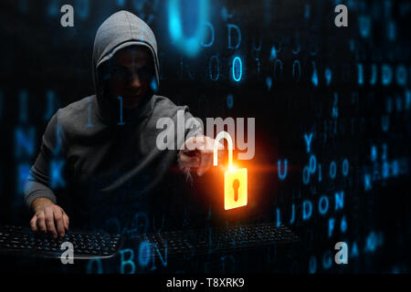 Hacker in hoodie dark theme Stock Photo