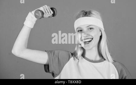 Vintage sport concept. Woman exercising with dumbbells. Easy exercises with dumbbells. Workout with dumbbells. Biceps exercises for women with step by step guide. Girl hold dumbbells wear wristbands. Stock Photo