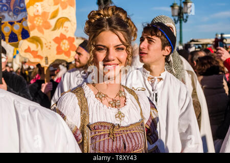 A beautiful young women is getting carried by young men at the procession Festa delle Marie Parade along the Grand Canal, Canal Grande Stock Photo