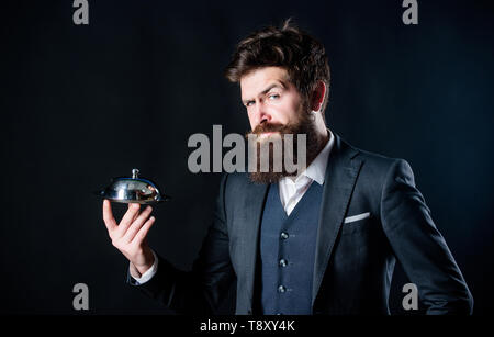 Secret under cloche. Elite luxurious. Exclusive food hidden cloche. Here is your meal. Something special. Man well groomed bearded gentleman formal suit hold little cloche. Serving and presentation. Stock Photo