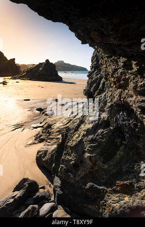 Evening light over rocks exposed at low tide on Great Western Beach in Newquay in Cornwall.