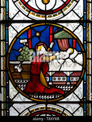 Stained glass window biblical healing scenes, raising daughter Jairus by Clayton and Bell, 1872 in church, Potterne, Wiltshire, England, UK Stock Photo