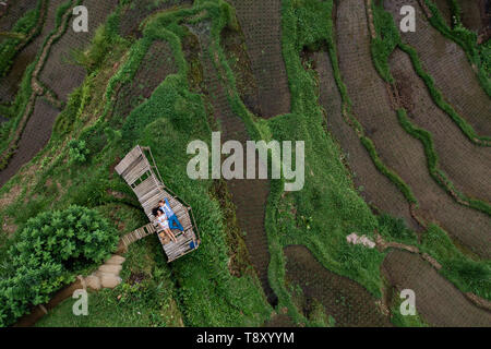 Aerial view on top. Two lovers of young people lie on a wooden bridge. Happy couple traveling at Bali, rice terraces of Tegalalang, Ubud. Honeymoon Stock Photo