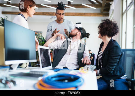 Group of young businesspeople talking in office, start-up concept. Stock Photo