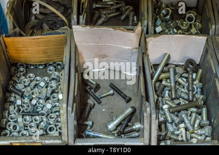 Metal screws and steel bolts in a storage room of a factory. Stock Photo