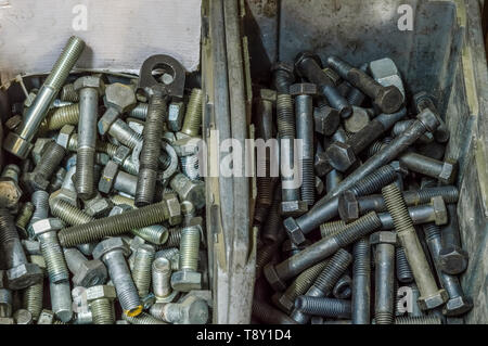 Metal screws and steel bolts in a storage room of a factory. Stock Photo