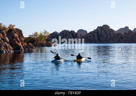 A man and woman kayaking on the early morning on Watson Lake under blue skies in Prescott, Arizona, USA Stock Photo