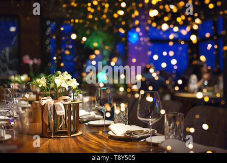 Blurred background of people sitting at restaurant, bar or night club with colorful lights bokeh. Stock Photo