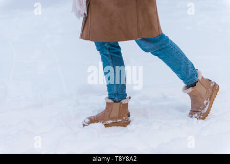 Cropped image of a pretty young woman walking outdoors in winter snow. Stock Photo