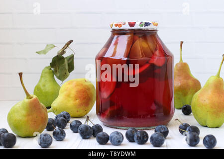 Compote of pears with blackthorn in a jar on a white background, Harvest for the winter Stock Photo