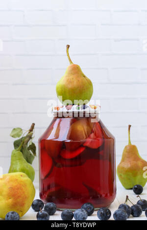 Compote of pears with blackthorn in a jar on a white background, Harvest for the winter Stock Photo