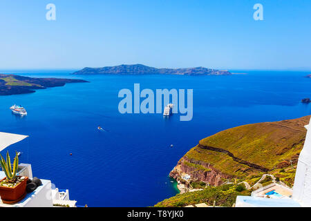 Santorini, Greece iconic view of white houses, caldera, volcano island and sea panorama with cruise ship Stock Photo