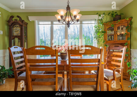 Grandfather clock, ash wood table and chairs plus buffet in dining room inside a country cottage style house, Quebec, Canada. This image is property released. CUPR0340