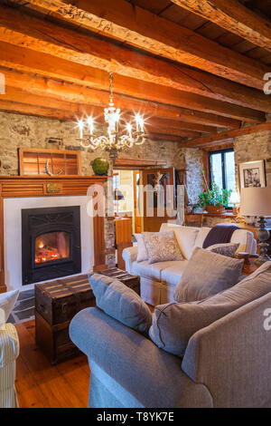 Lit Factory Built Slow Burning Wood Fireplace With Grey And Beige