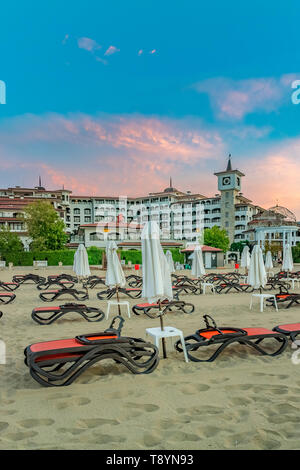 Sunny Beach, Bulgaria - 4 Sep 2018: Umbrellas and chair lounges at sunrise in Sunny Beach, a major seaside resort on the Black Sea coast of Bulgaria. Stock Photo