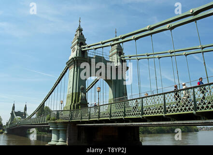 pedestrians use the footway of hammersmith bridge, crossing the river thames between barnes and hammersmith, london, england Stock Photo