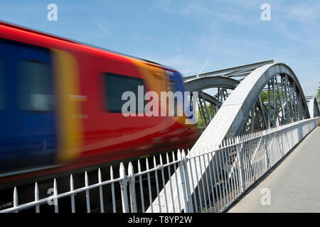 a south western railway train crosses barnes bridge, on the river thames in southwest london, as it enters barnes station Stock Photo